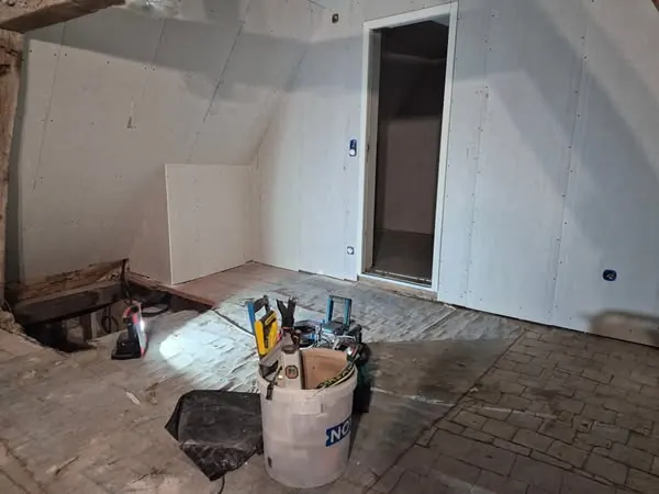 Pièce sous combles doublée en plaques de plâtre, bloc-porte posé, bandes à venir