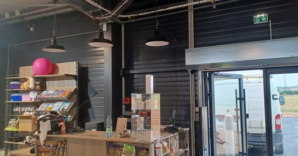 Éclairage suspendu installé dans un commerce au plafond peint en noir
