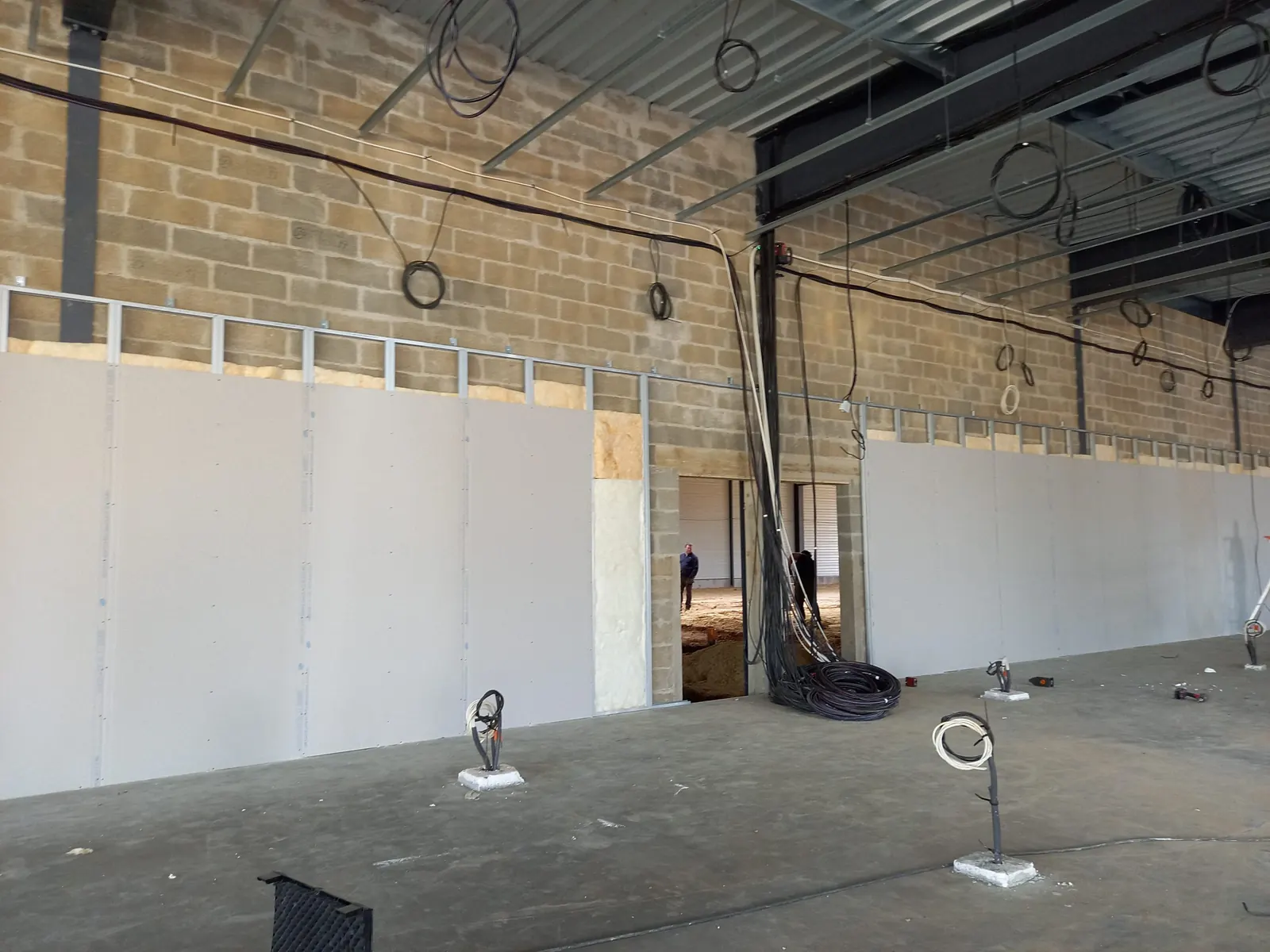 Hall industriel : cloisons en plaques de plâtre montées sous charpente métallique