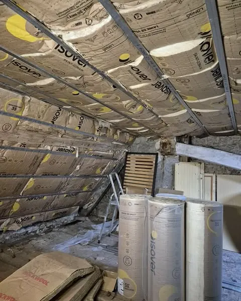 Isolation des rampants en laine de verre entre chevrons, rouleaux en attente